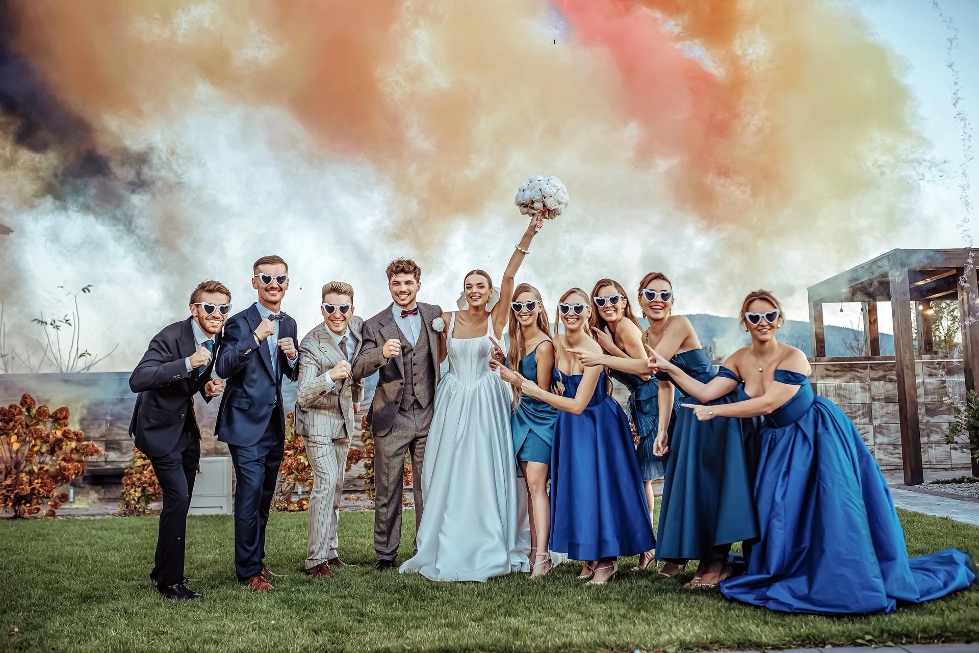 Wedding party of groomsmen in navy and groom in tan suit with bride in white dress